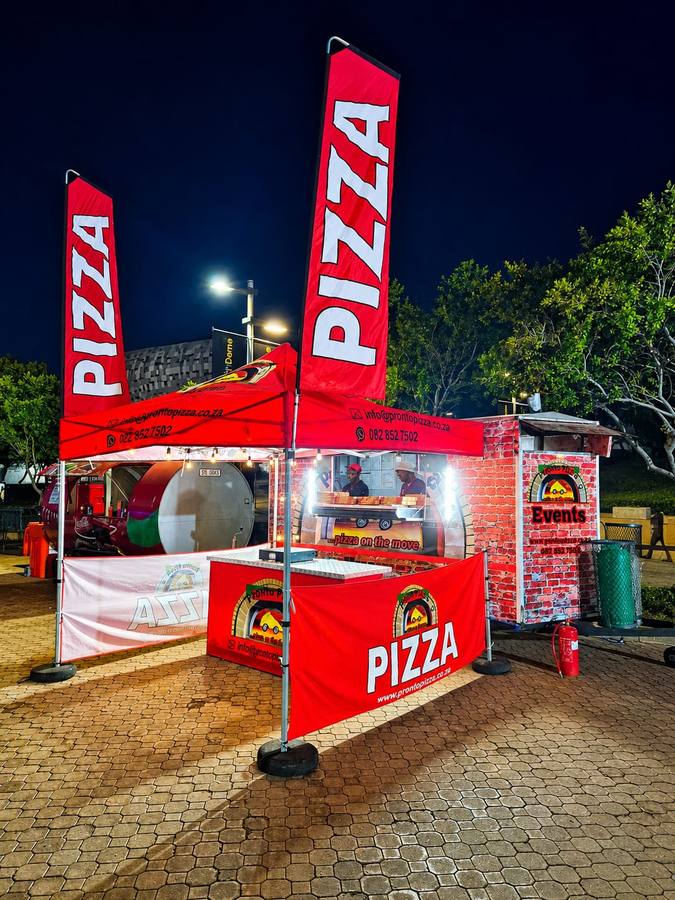 Pronto Pizza stall lit up at an evening event