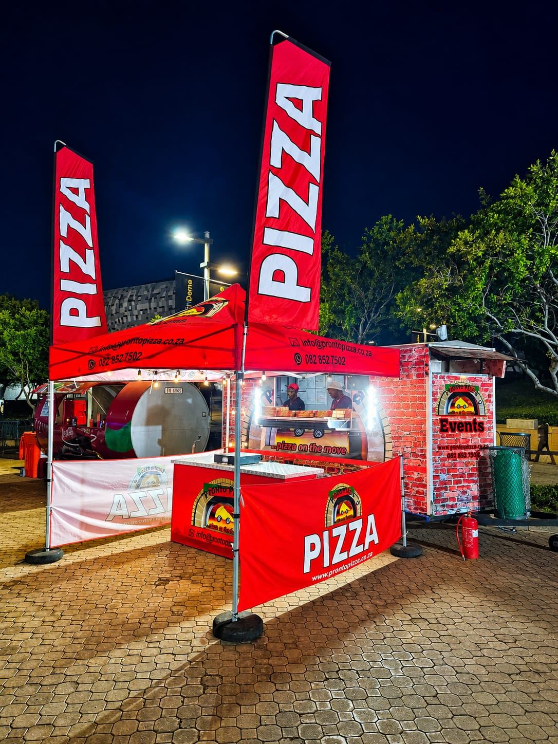 The Pronto Pizza stall lit up at a night event